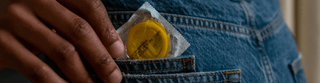 A person discreetly holds a condom in their pocket, emphasizing safe practices and personal responsibility.